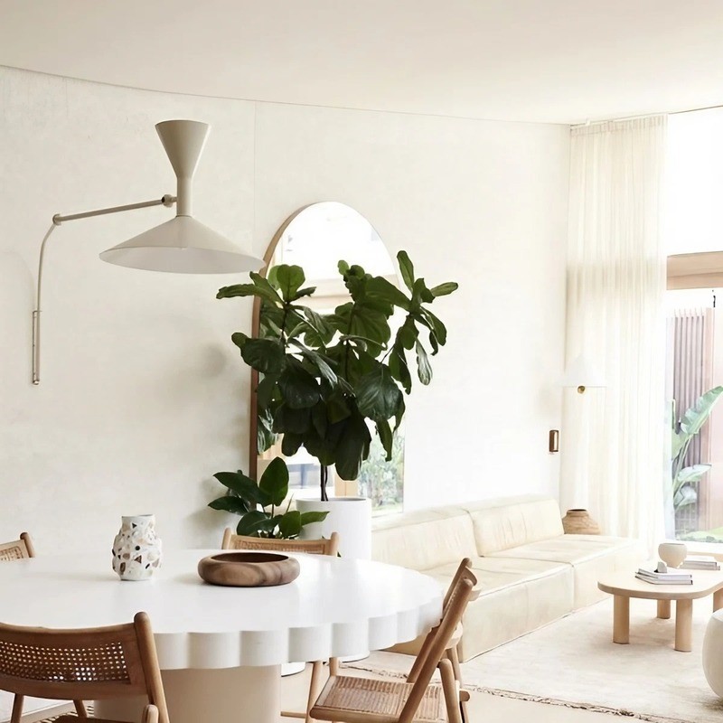 White adjustable wall lamp in a bright living and dining setting