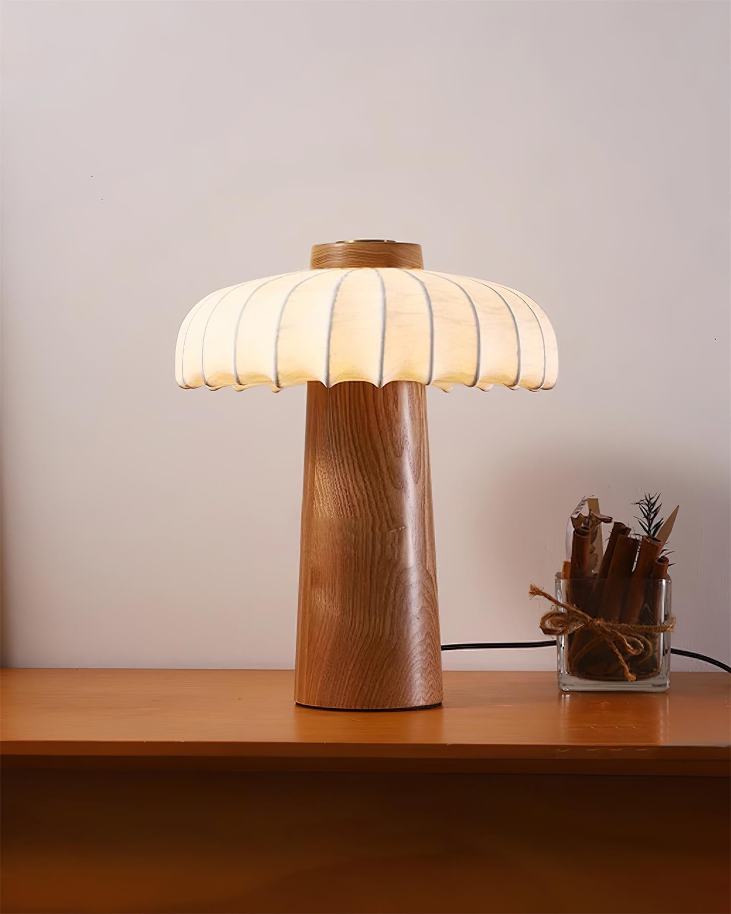 Lampa stołowa Juego w kolorze drewna zapalona na biurku