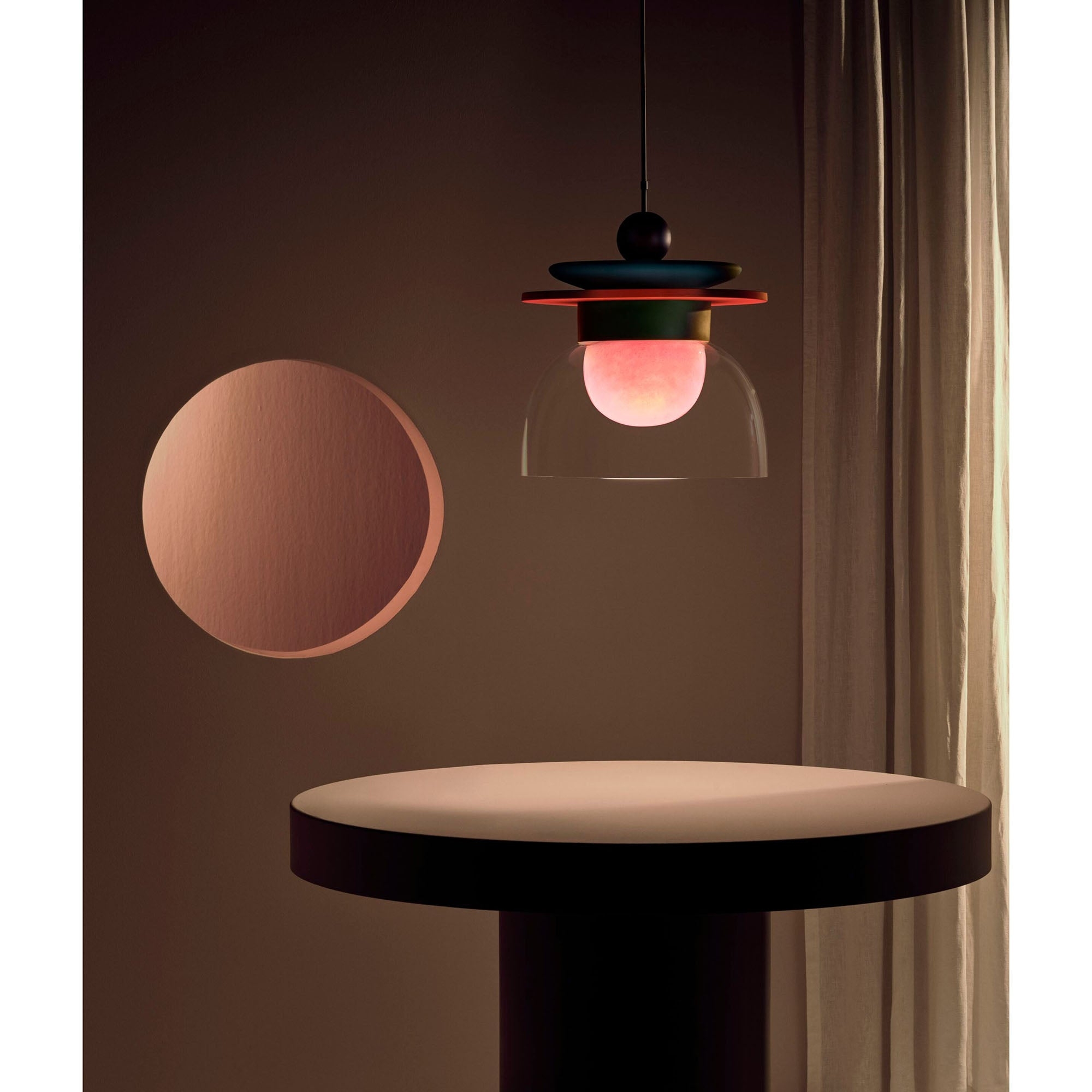 Lampa wisząca Eirene świecąca w ciemniejszej scenie na stole
