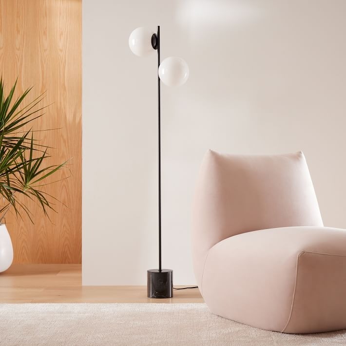 Lámpara de pie Brina totalmente visible en una habitación minimalista.