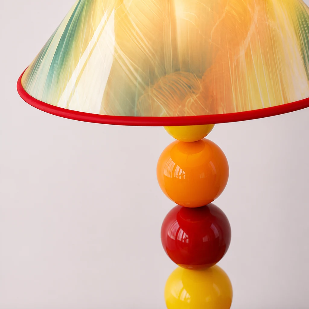 Zbliżenie na kolorowy abażur lampy stołowej i ułożoną w stos kulę