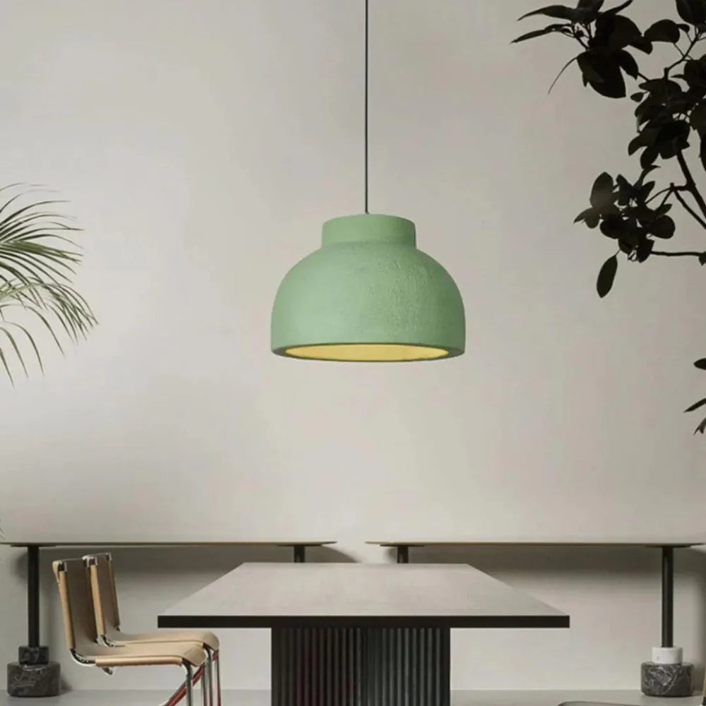 Lámpara colgante verde sobre una mesa minimalista