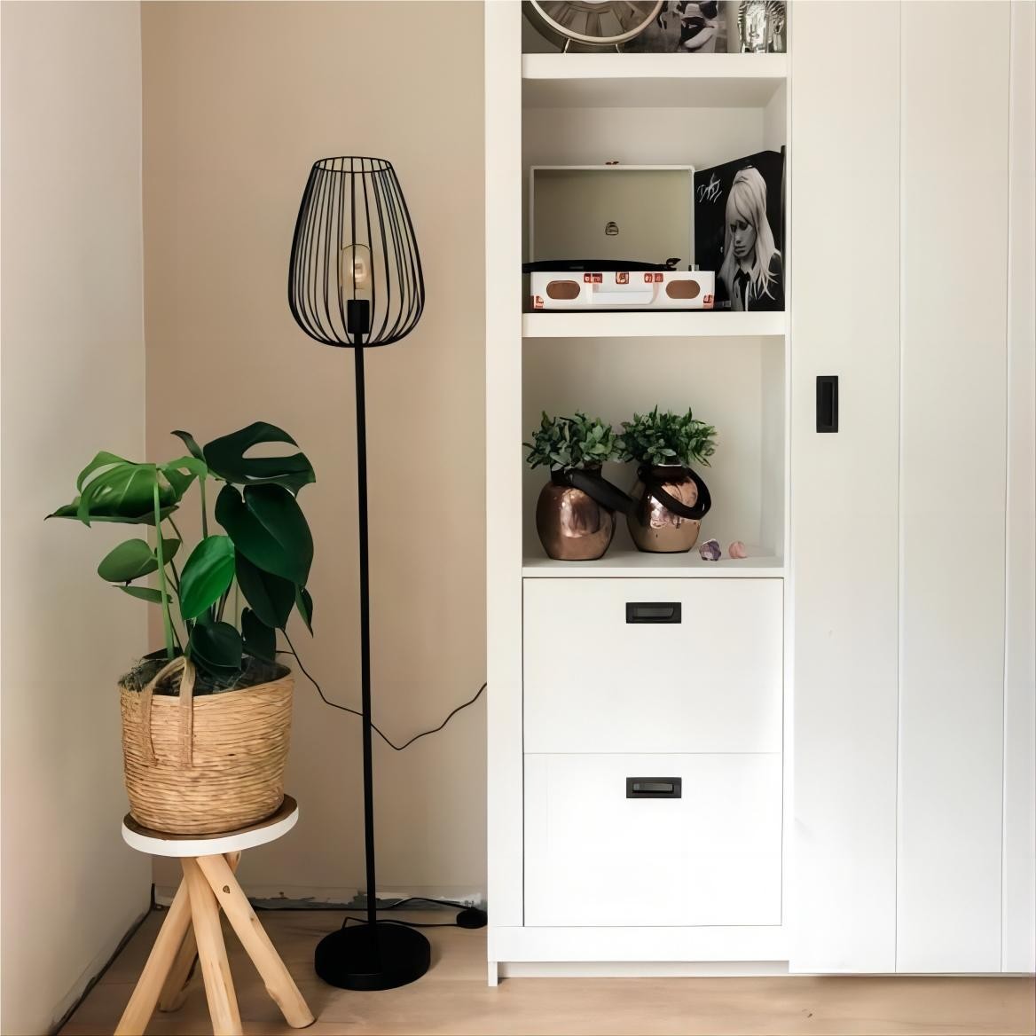 Lámpara de pie S69 junto a estanterías y plantas.