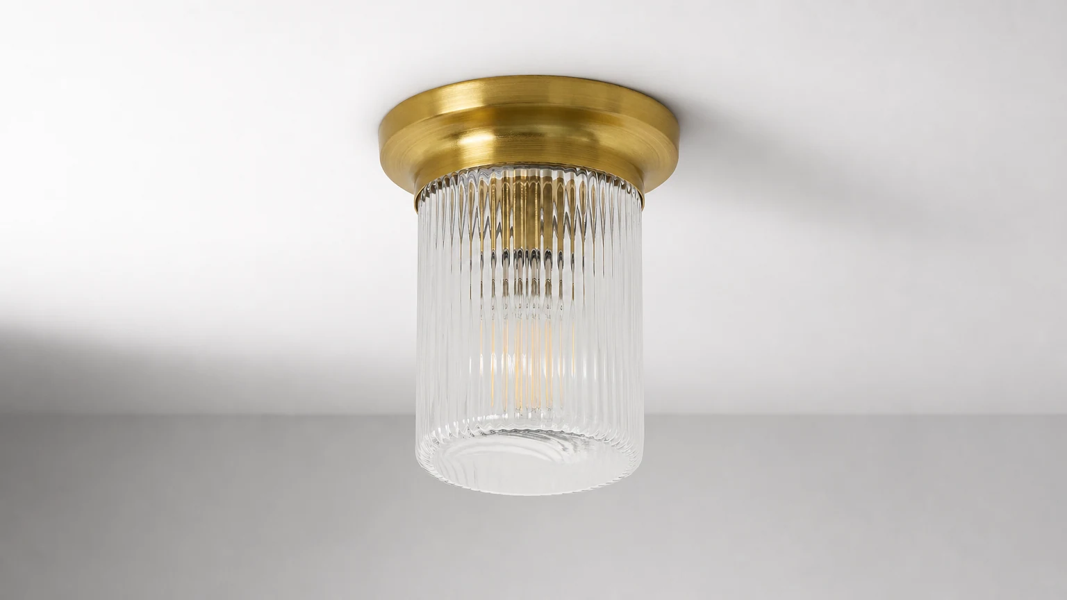 Lámpara de techo empotrada de cristal estriado Rivora instalada en un interior cálido.