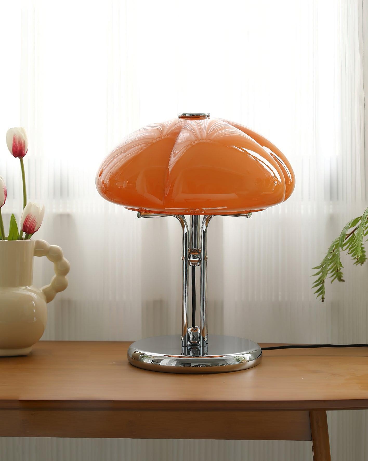 Pomarańczowa szklana lampa grzybkowa na stole w pobliżu zasłon