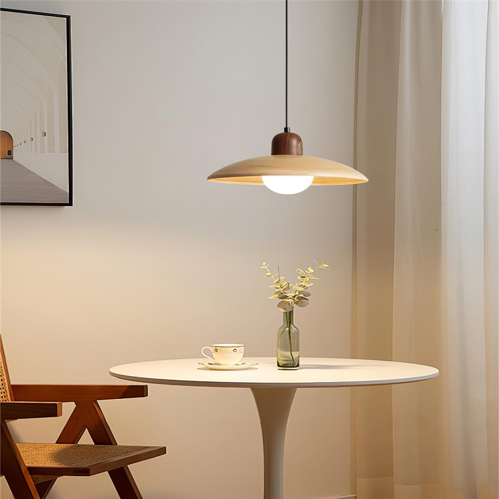 Lampa wisząca nad okrągłym stołem w prostym pokoju