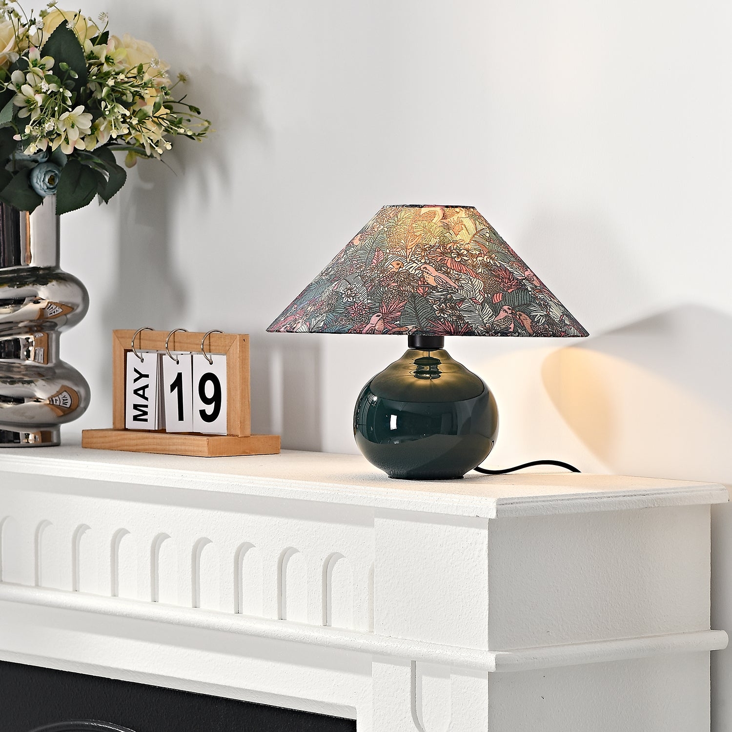 Zapalona lampa Kalinda w scenie stylu życia z białym kominkiem