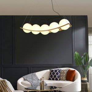 Zakrzywiona lampa wisząca Pea w salonie nad częścią wypoczynkową