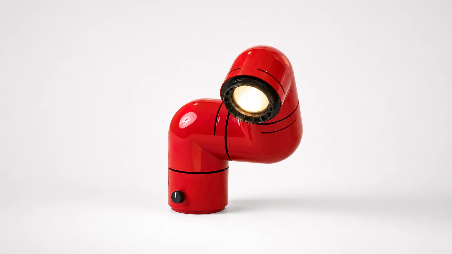 Rød rørformet bordlampe M20 vist i et soverom