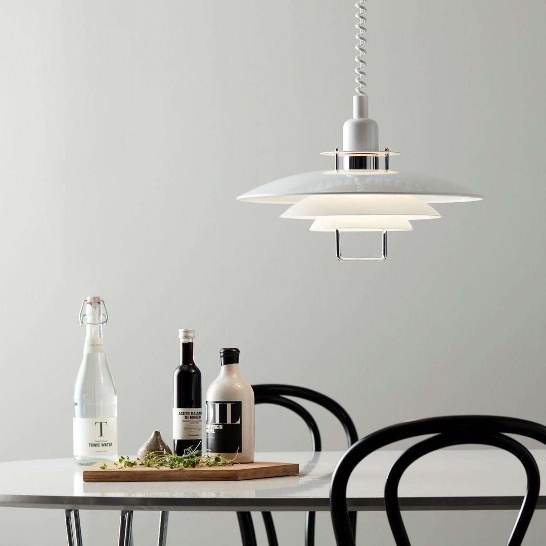 Lampa wisząca UFO wisząca nad stołem w jadalni z butelkami i krzesłami