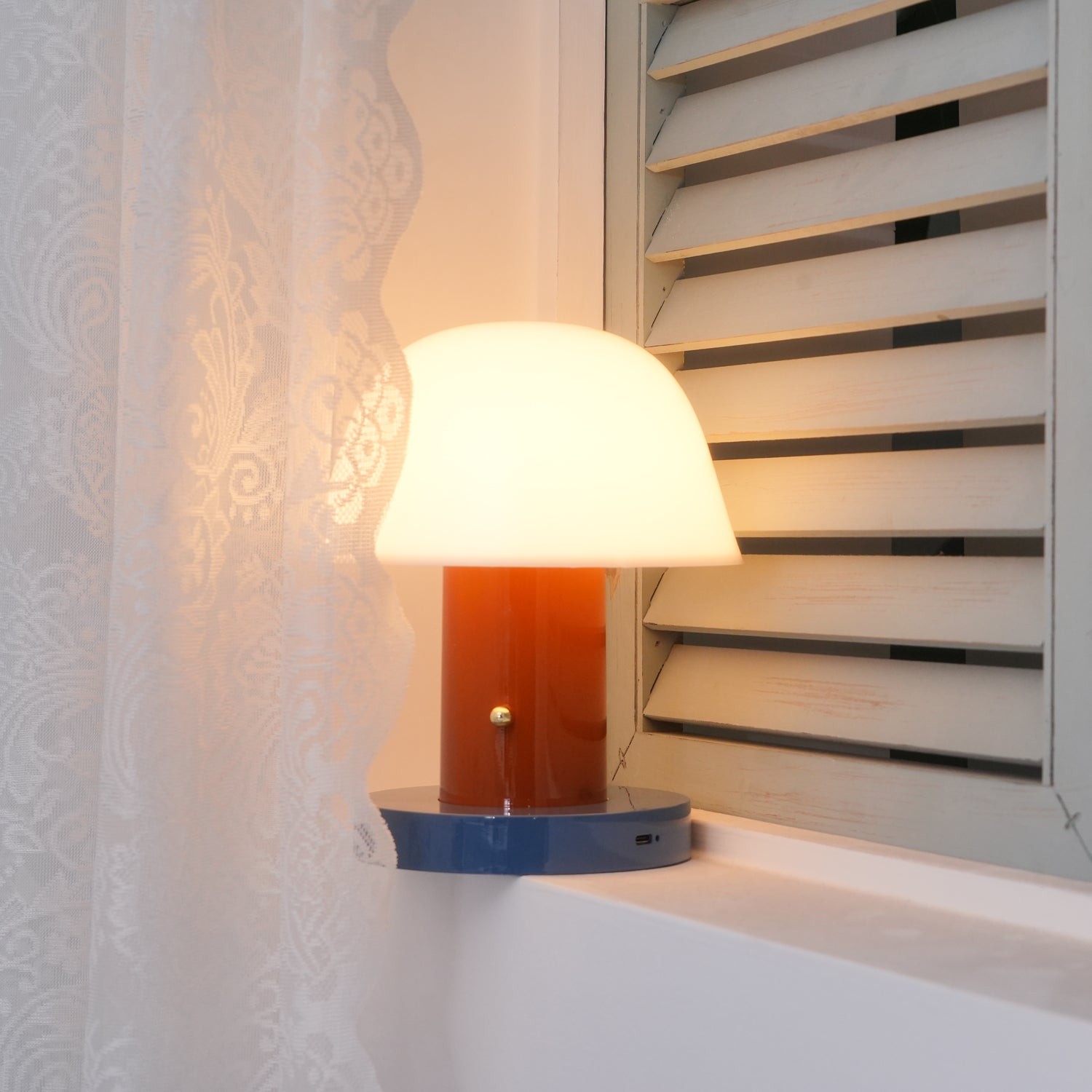 Sopplignende trådløs lampe ved et vindu
