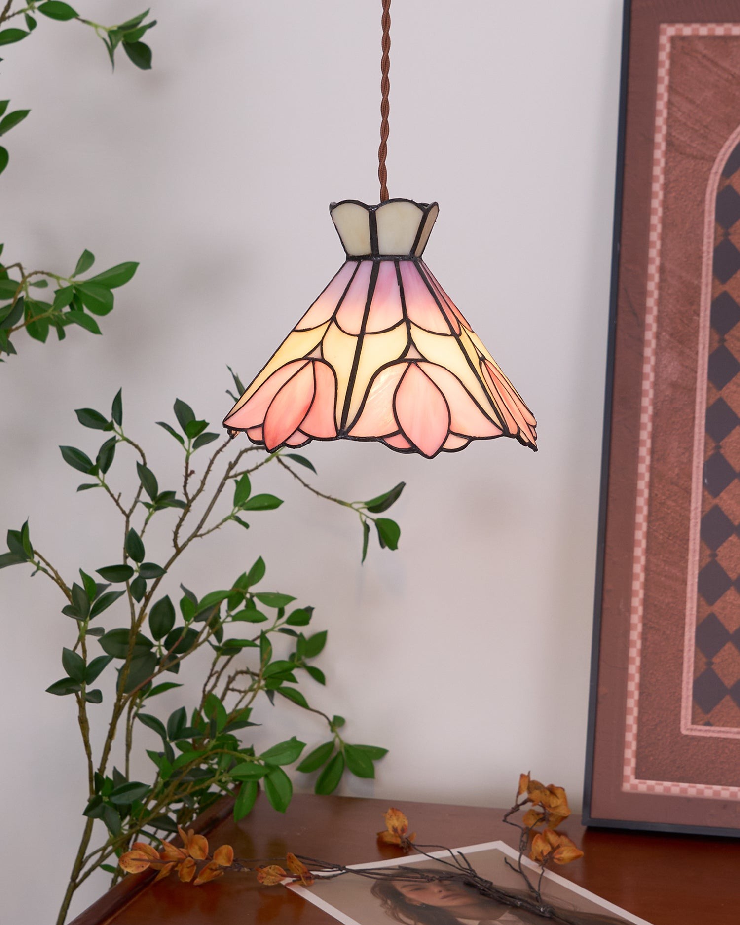 Lampa wisząca retro Tiffany w urządzonym wnętrzu ze sztuką i roślinami