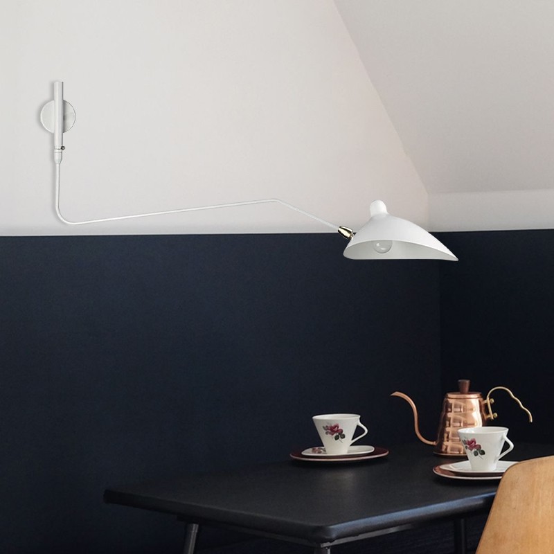Hvit vegglampe installert over en mørk vegg og bordscene