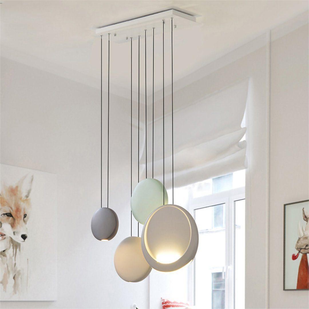Gruppi di lampade a sospensione Cosmos installate da un rosone a soffitto.