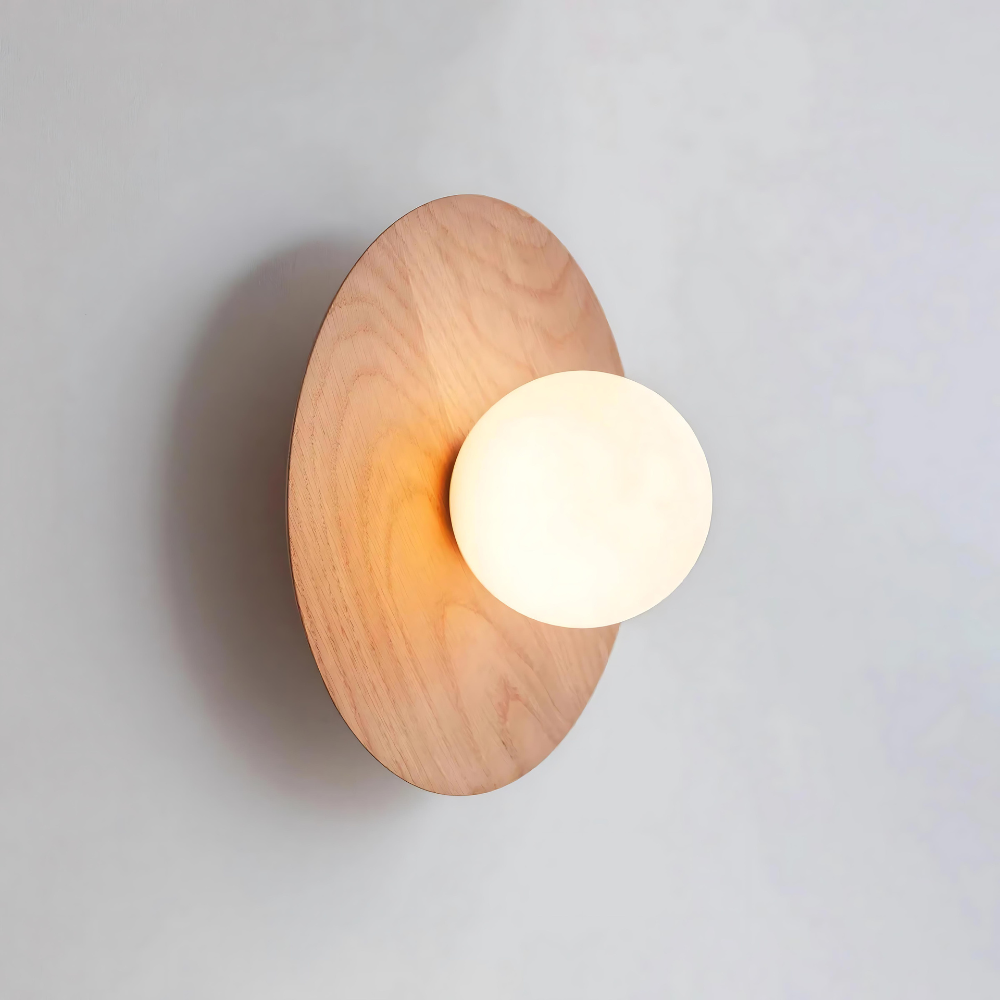 Primer plano de la lámpara de madera Serenity, donde se aprecia el disco de madera y la pantalla de cristal brillante.