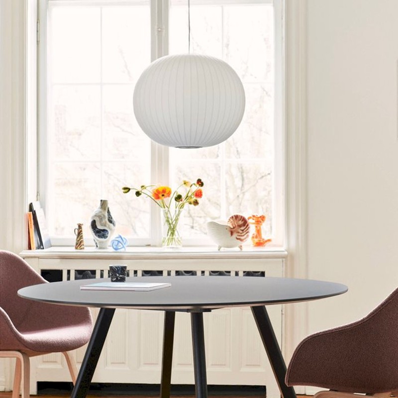 Lámpara colgante redonda con forma de burbuja en un luminoso interior de comedor.
