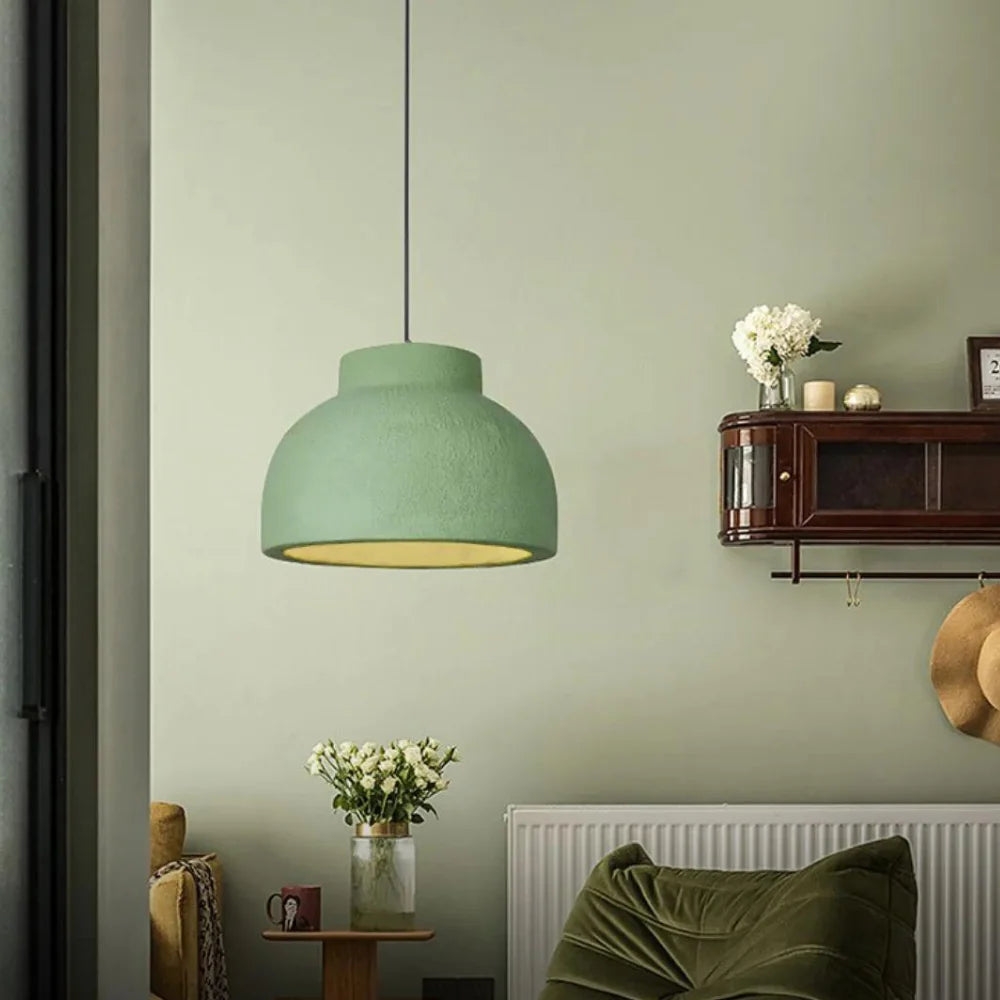 Variante de lámpara colgante verde salvia en una escena de sala de estar.