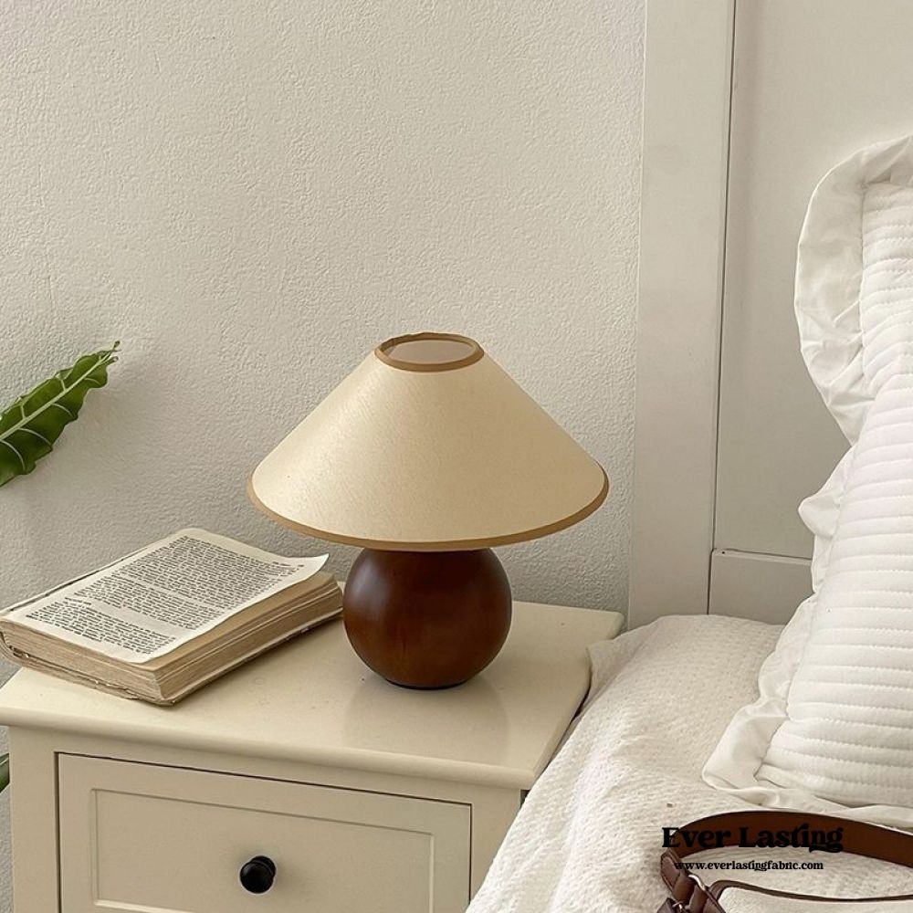 Lniana lampa stołowa Ambient S71 na stoliku nocnym z książką i pościelą