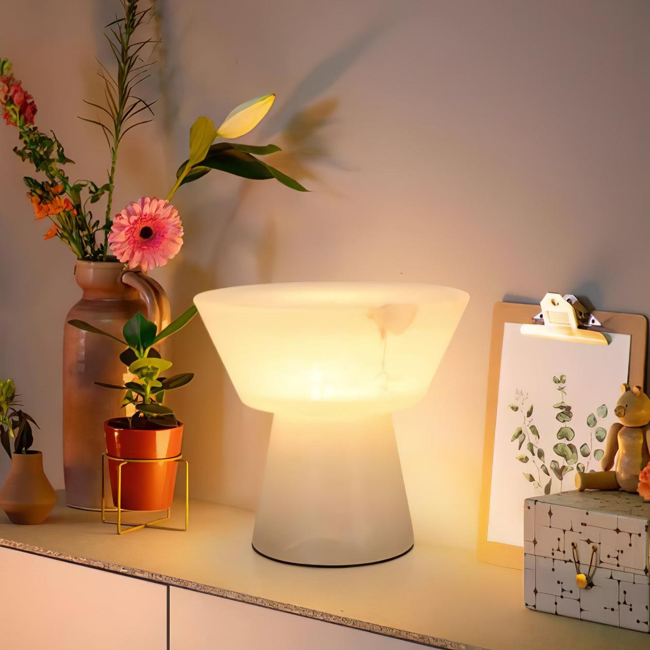 Lampa Beta Marble zapalona na blacie z ozdobnymi przedmiotami