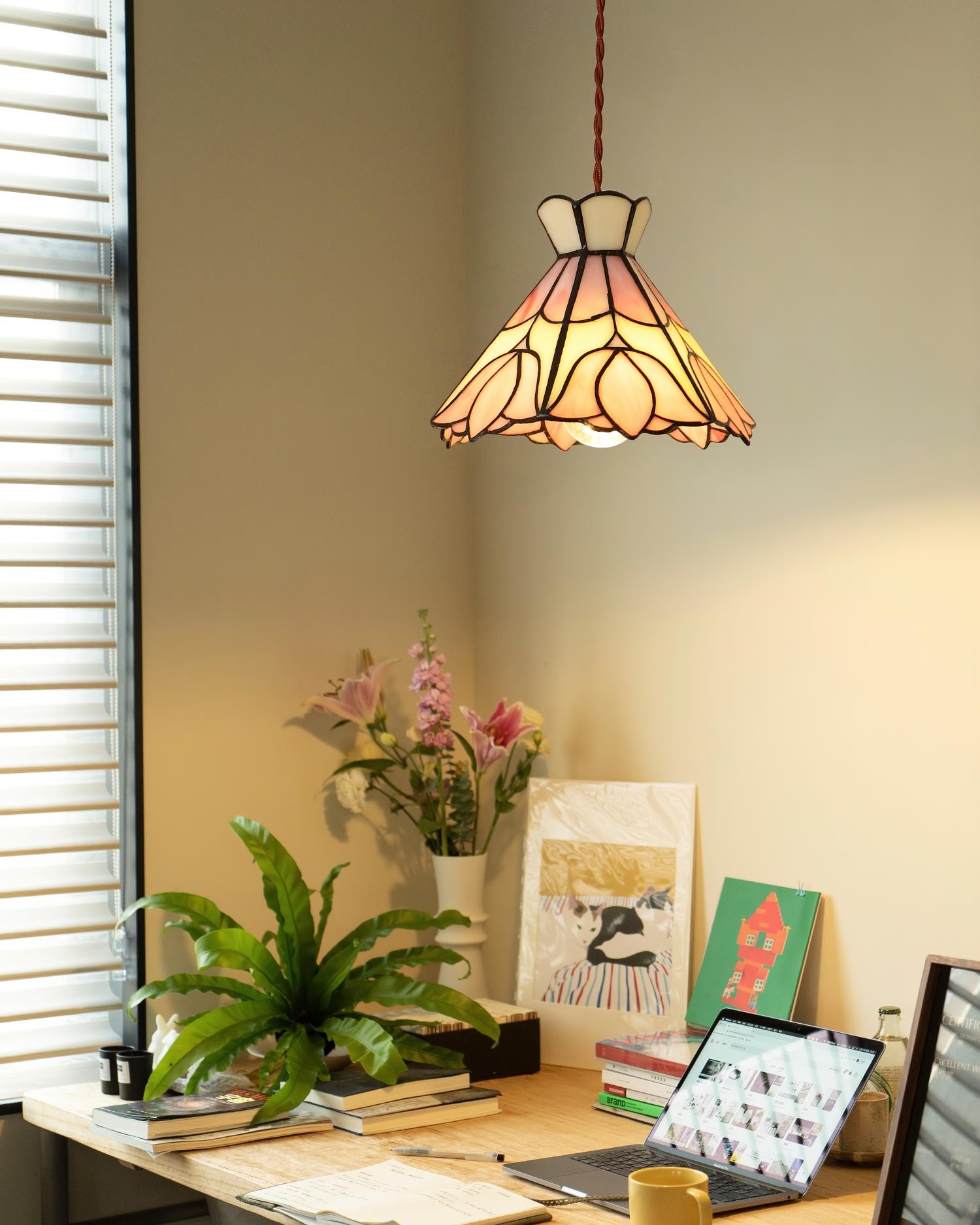 Retro lampa wisząca Tiffany nad biurkiem i roślinami