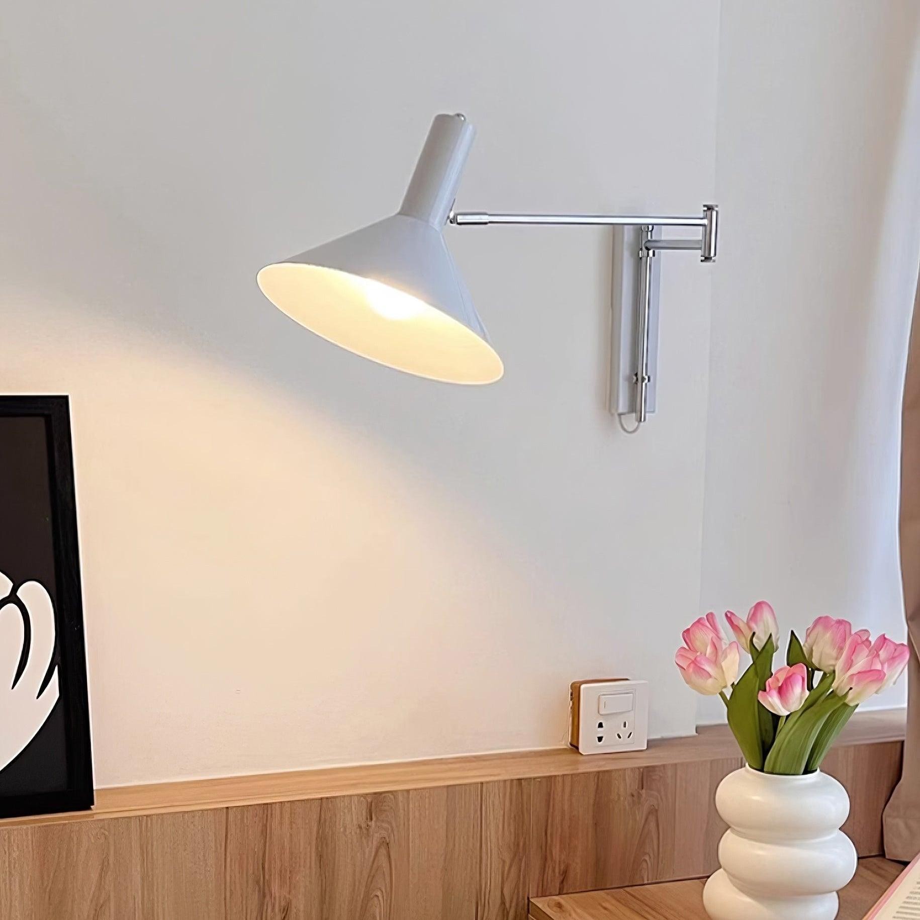Biała lampa ścienna z wahadłowym ramieniem nad dekoracją półki