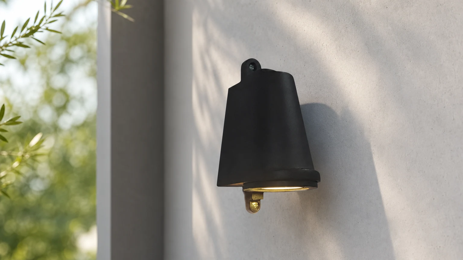 Aplique de pared exterior industrial con forma de campana instalado en una pared exterior.