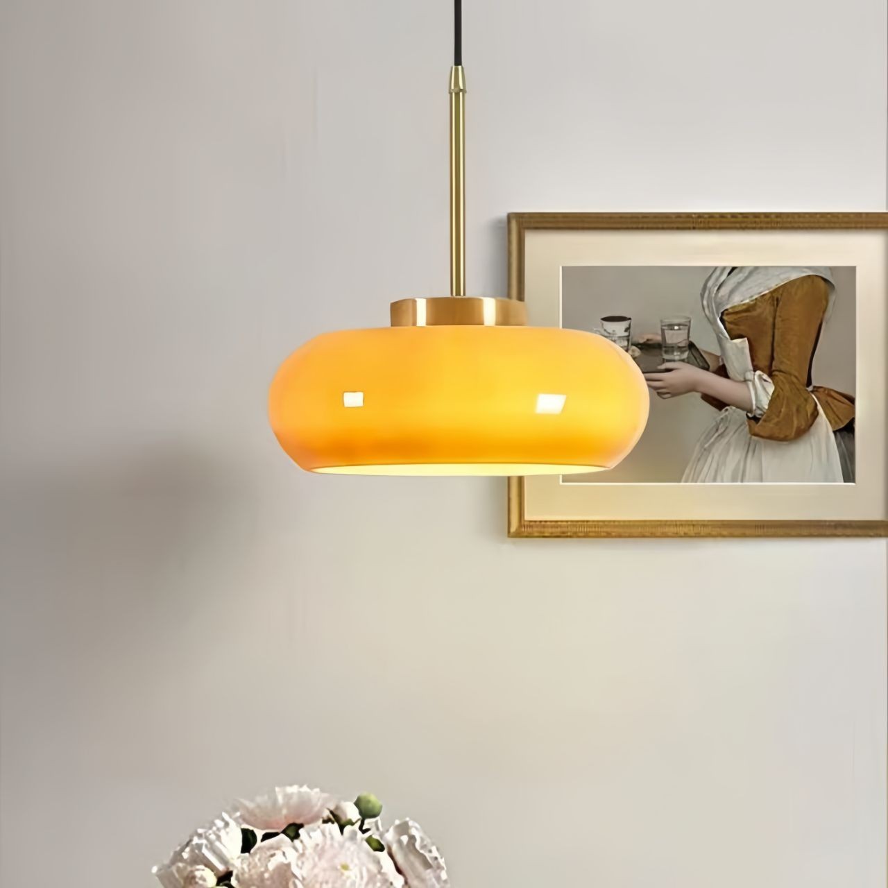 Pomarańczowo-żółta lampa wisząca S93 zainstalowana nad małym stołem