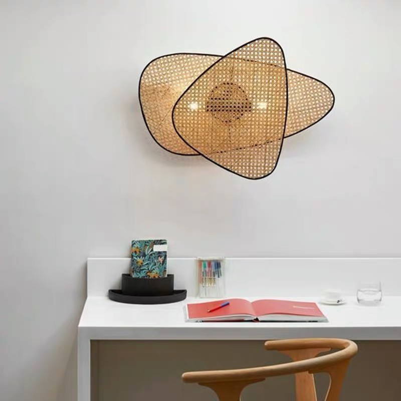 Eine Rattan-Wandleuchte ist über einem Schreibtisch angebracht.