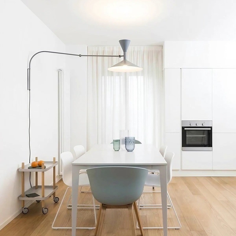 White adjustable wall lamp over a dining table