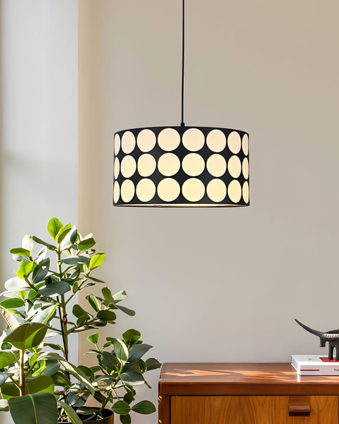 Zapalana lampa wisząca nad roślinami i meblami