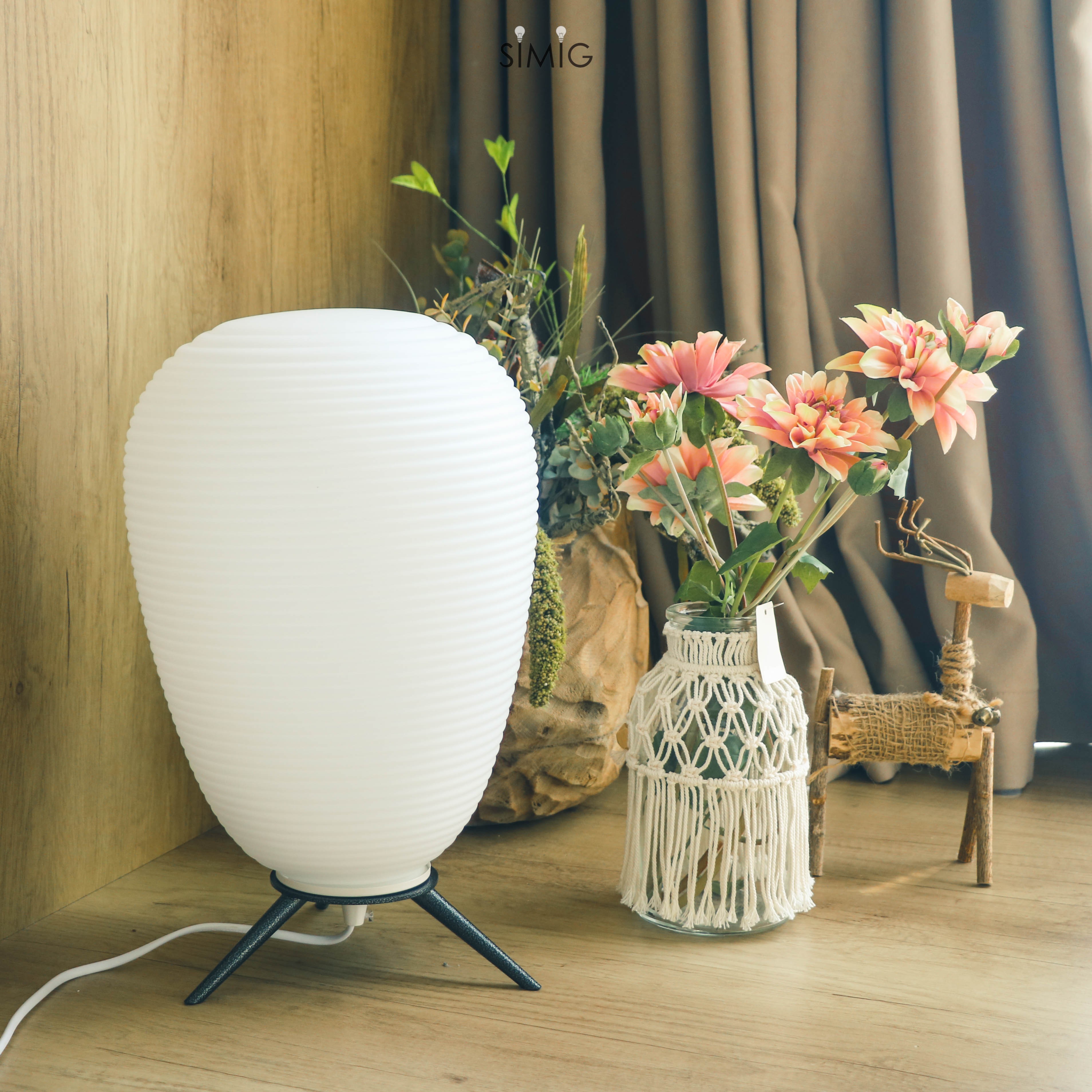 Lamp placed beside floral vase in decorated interior