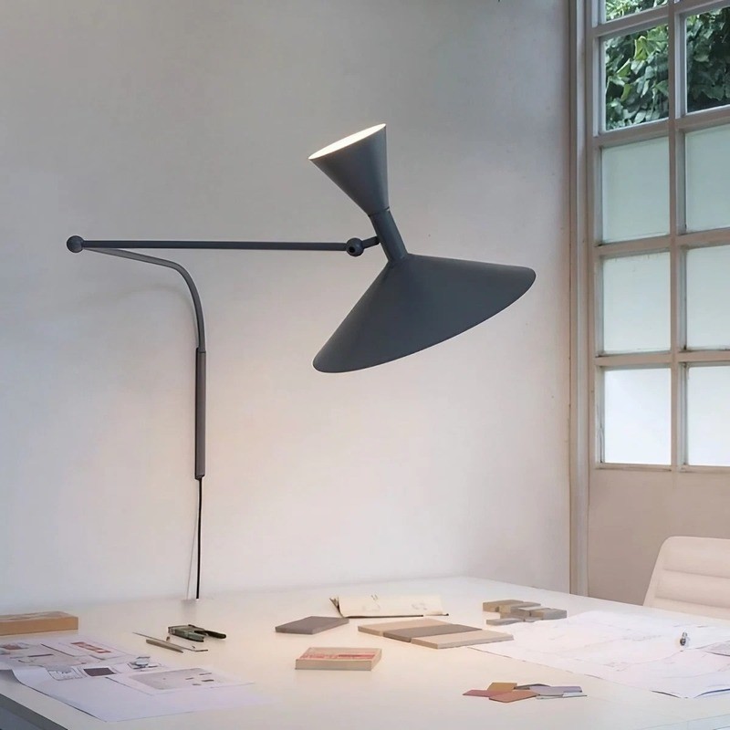 Black adjustable wall lamp mounted over a work surface