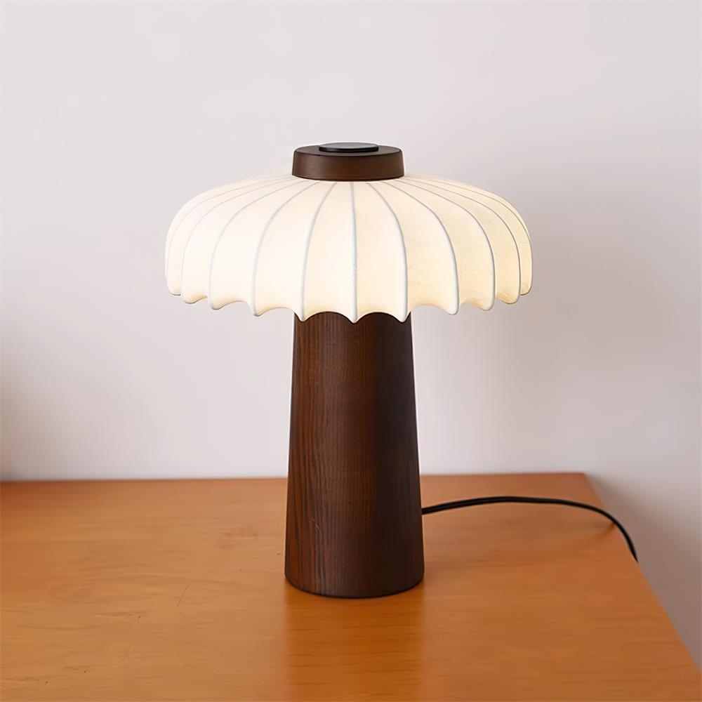 Lampa stołowa Juego zapalona na drewnianym blacie