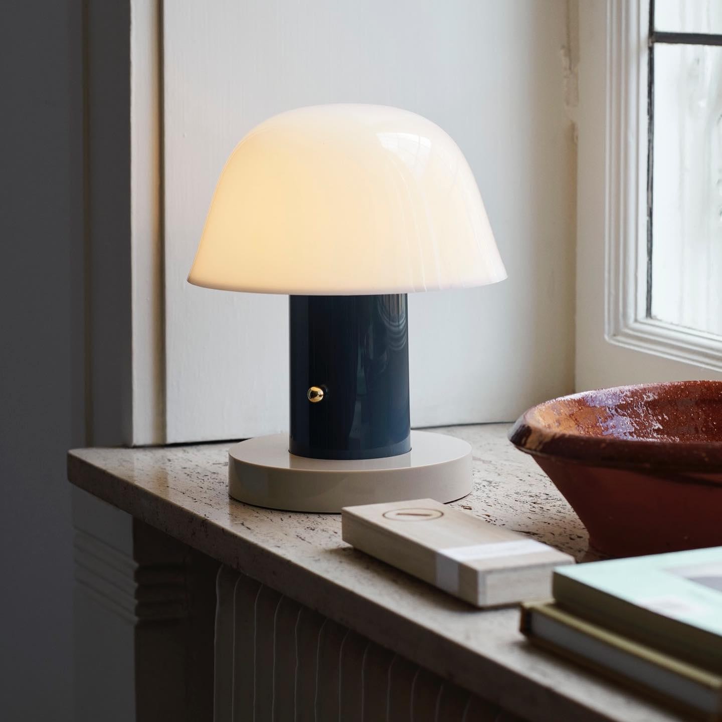 Blå og hvit sopp-trådløs lampe på en vinduskarm