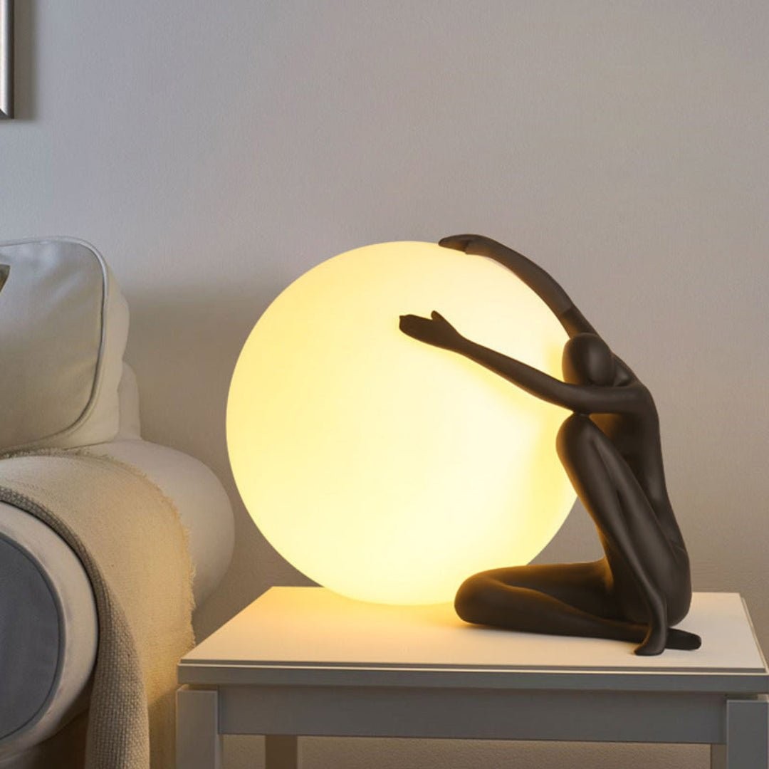 Humanoid Ball Holding Bordlampe M585 på sidebord ved siden av sofaen