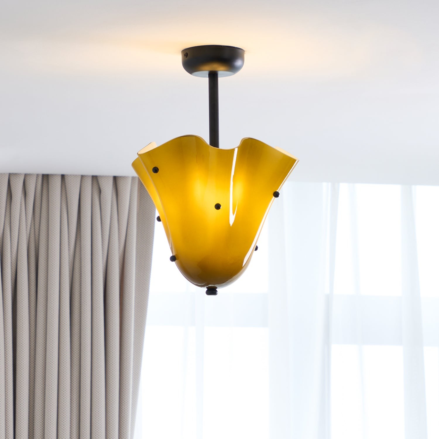 Bellina glastaklampa installerad nära gardiner