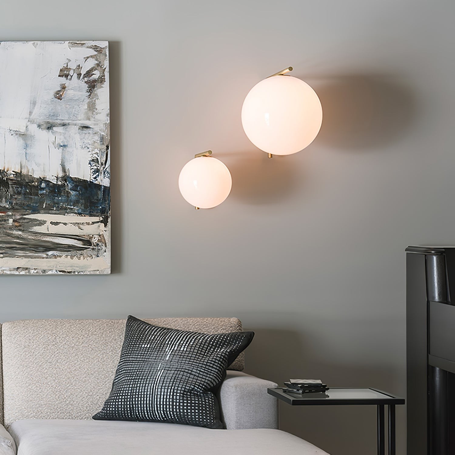 To globeformede vegglamper installert over en sofa i en stue med soverom