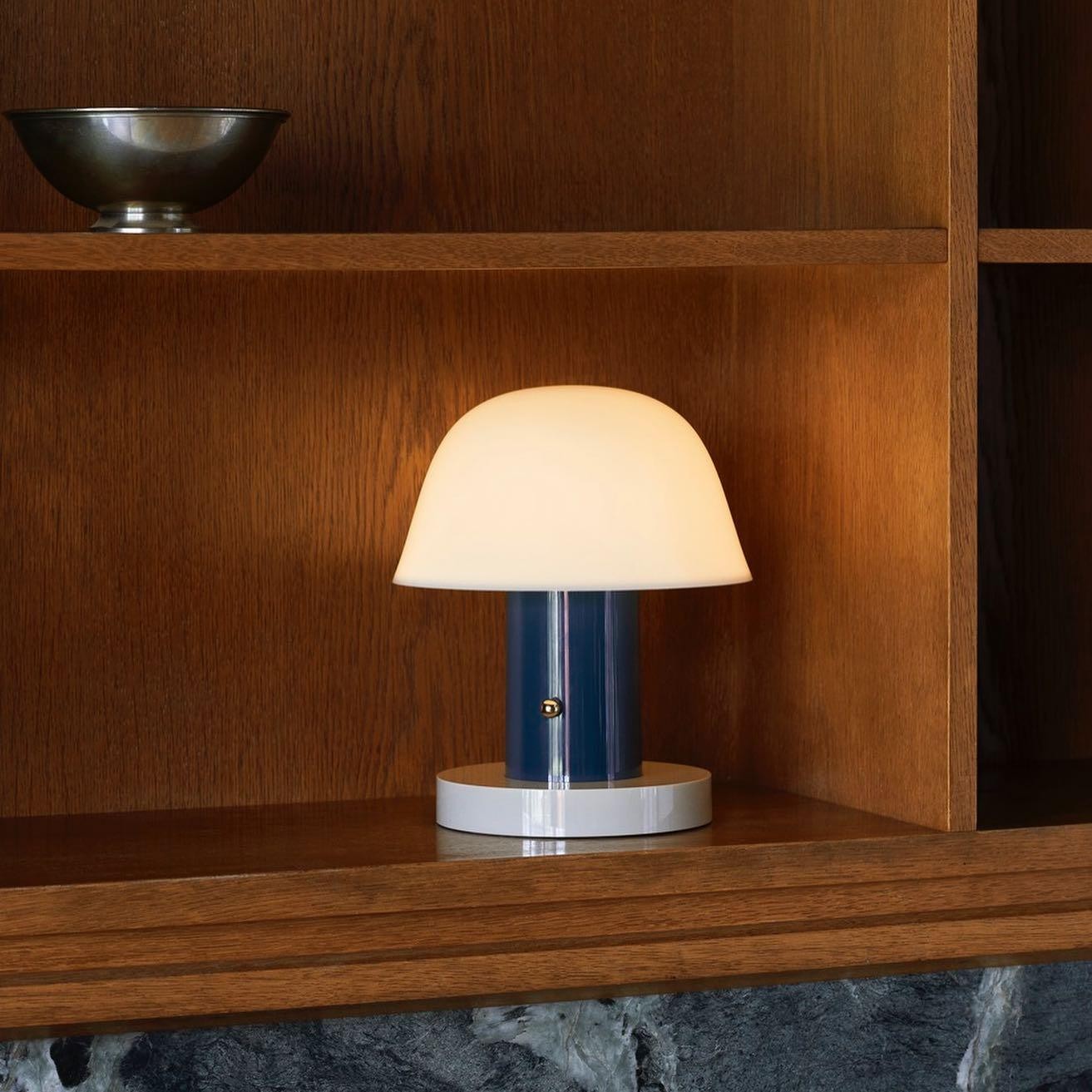 Sopplignende trådløs lampe på en trehylle