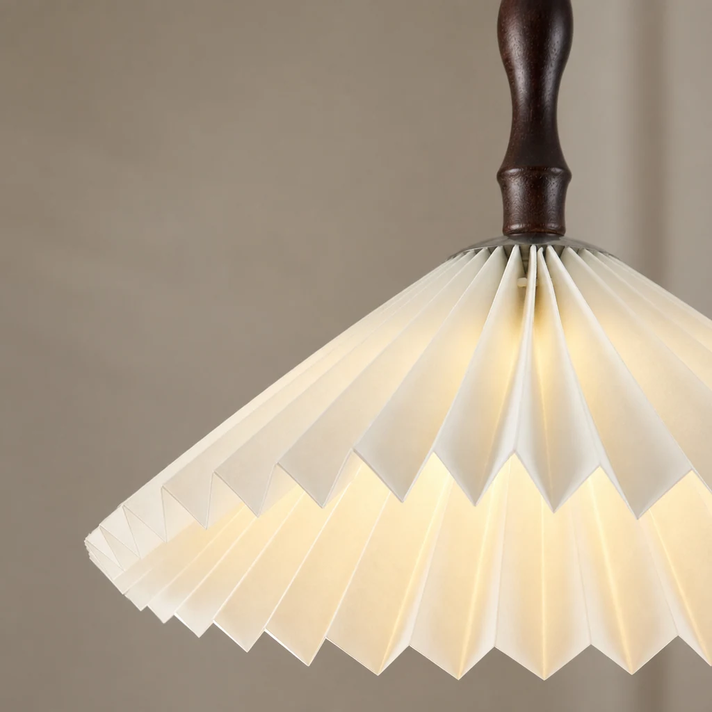 Zbliżenie na szczegóły abażuru lampy wiszącej z białego plisowanego kwiatu