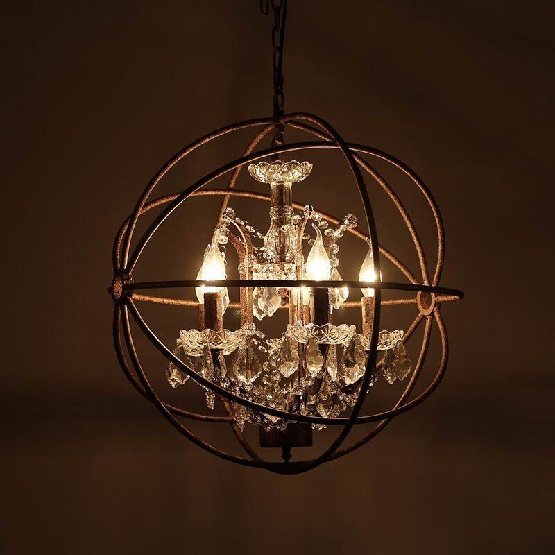Lampadario retrò a gabbia in ferro arrugginito, illuminato su uno sfondo scuro e caldo.