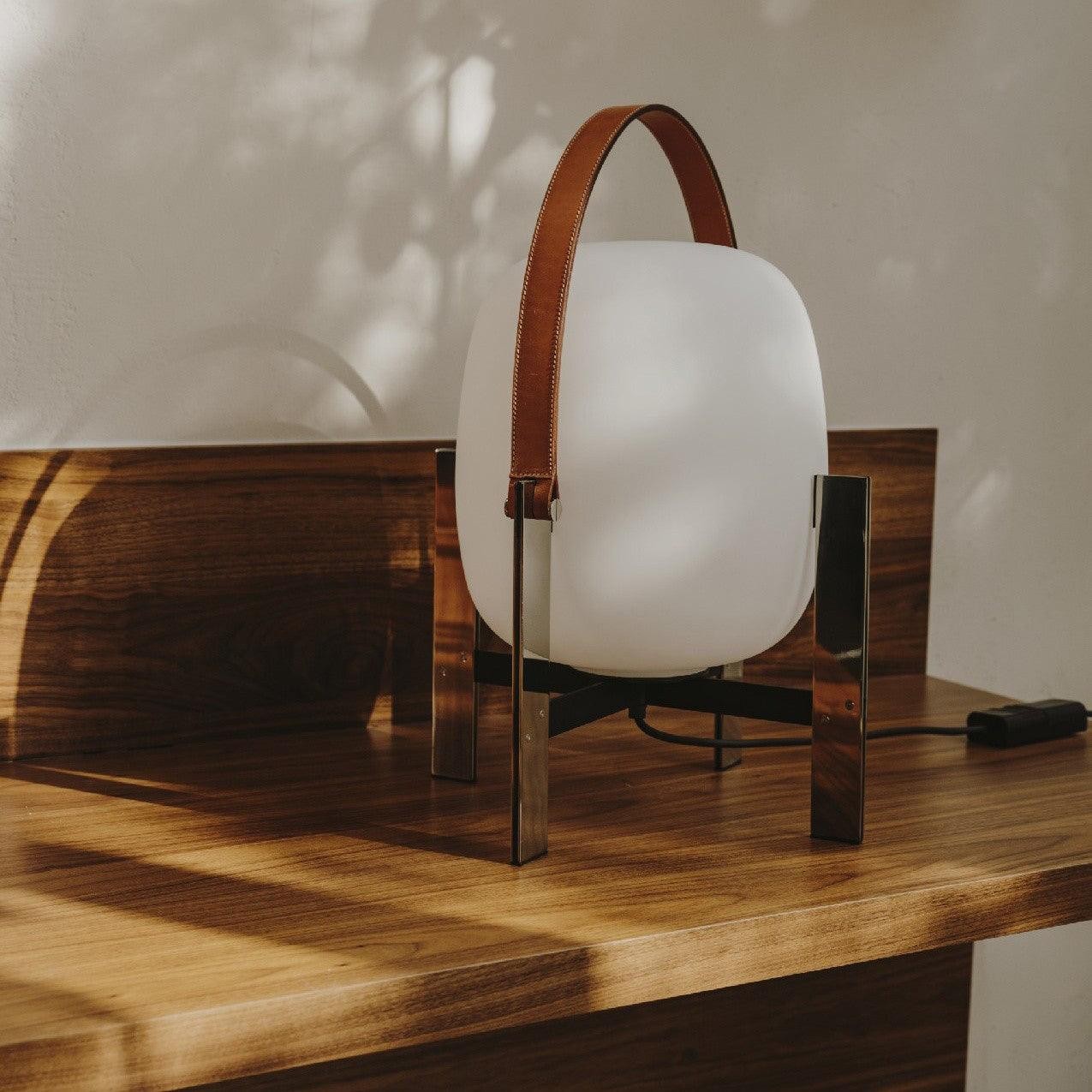 Bærbar lanternebordlampe M31 på et trebord i sollys