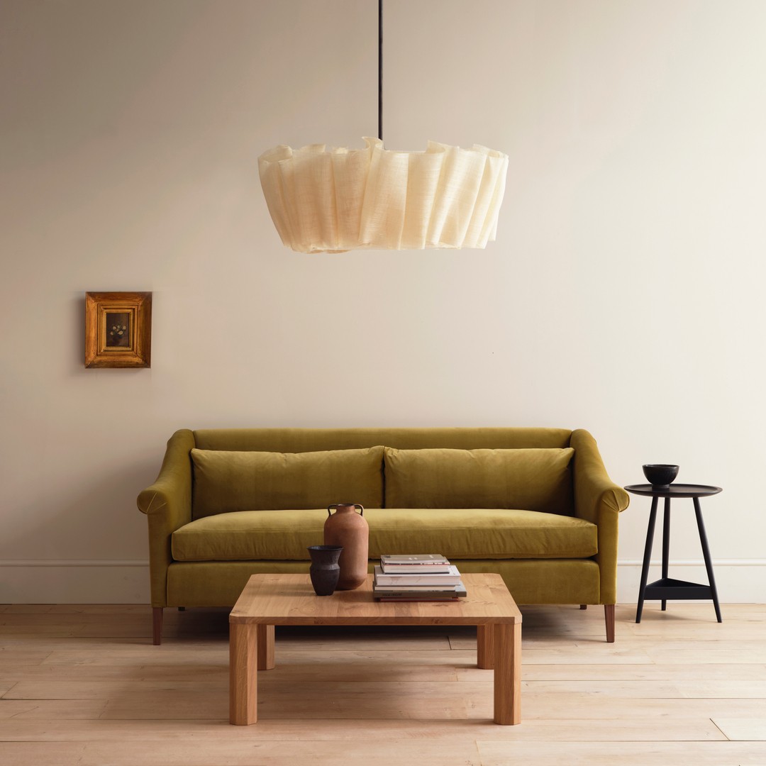 Lampa wisząca umieszczona centralnie nad sceną z sofą