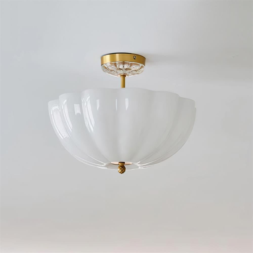 Installert melkehvit glassblomsttaklampe mot tak- og veggbakgrunn