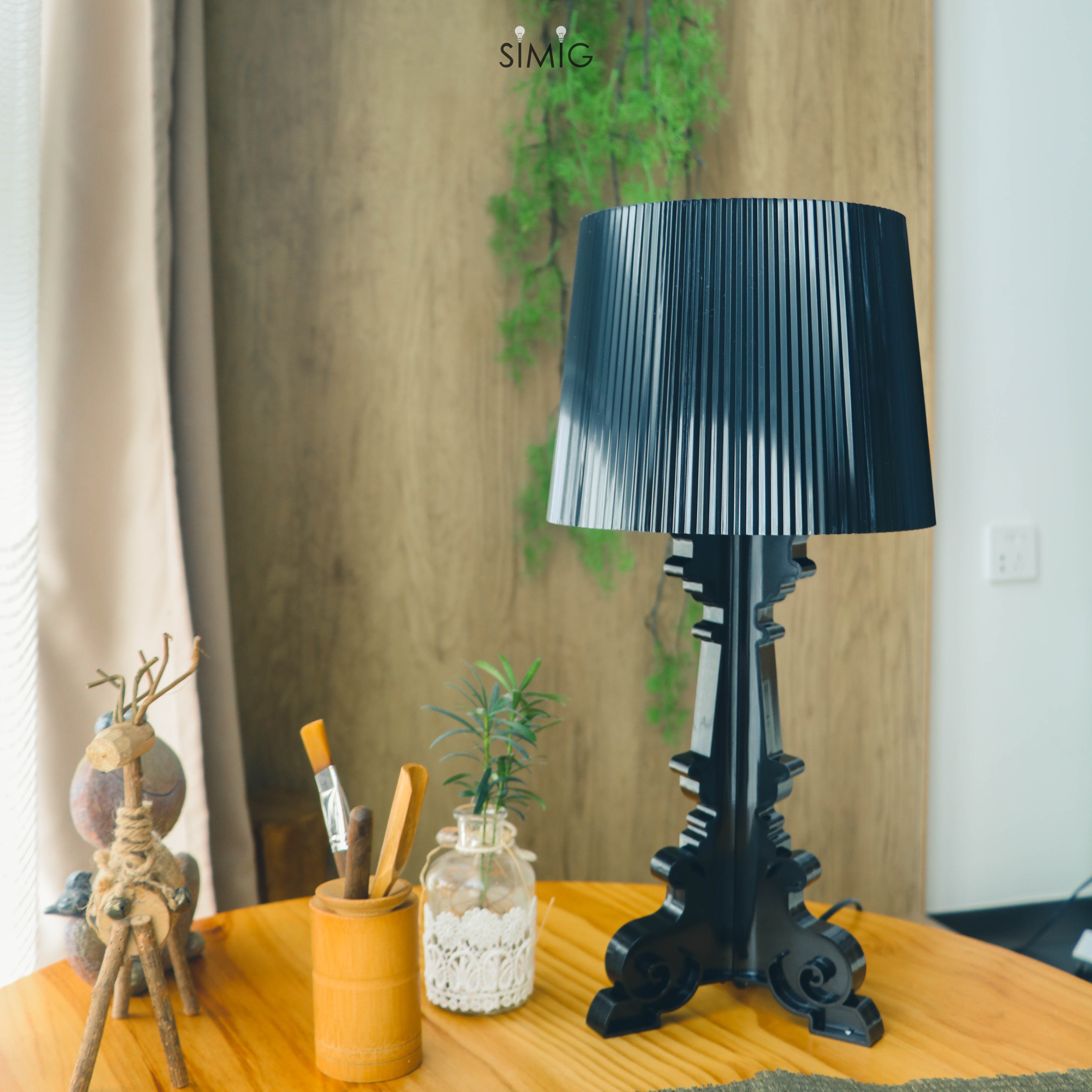 Black Bourgie lamp on tabletop with decorative objects