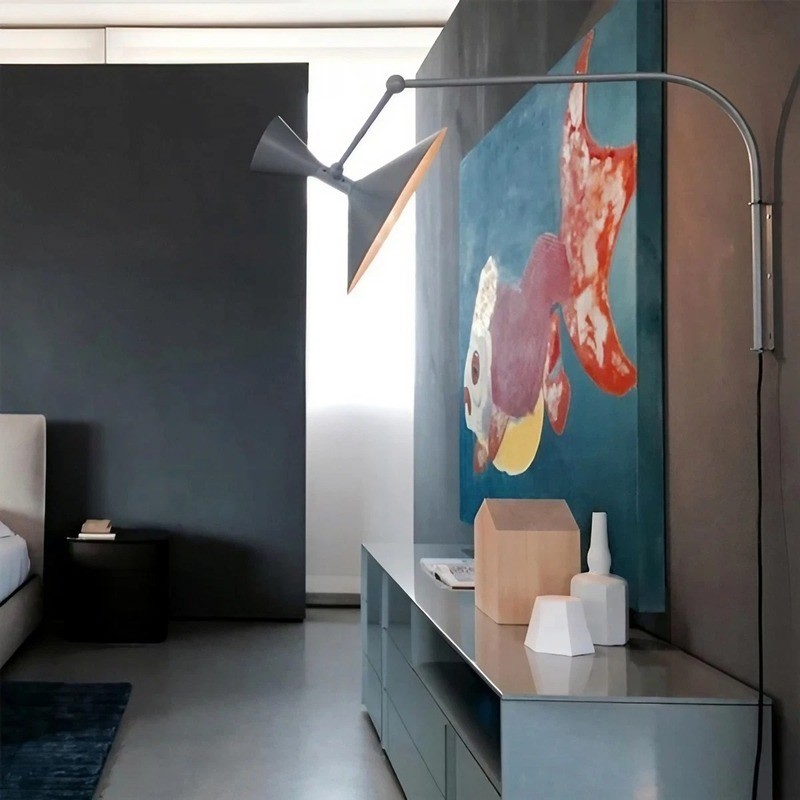 Black adjustable wall lamp near a dark living room media wall