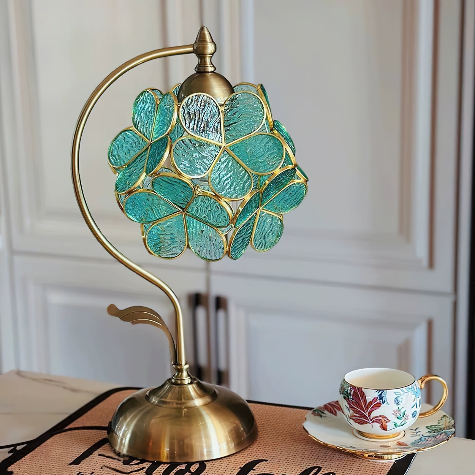 Bordlampe med kronblad utstilt med romdekor og kopp for skala