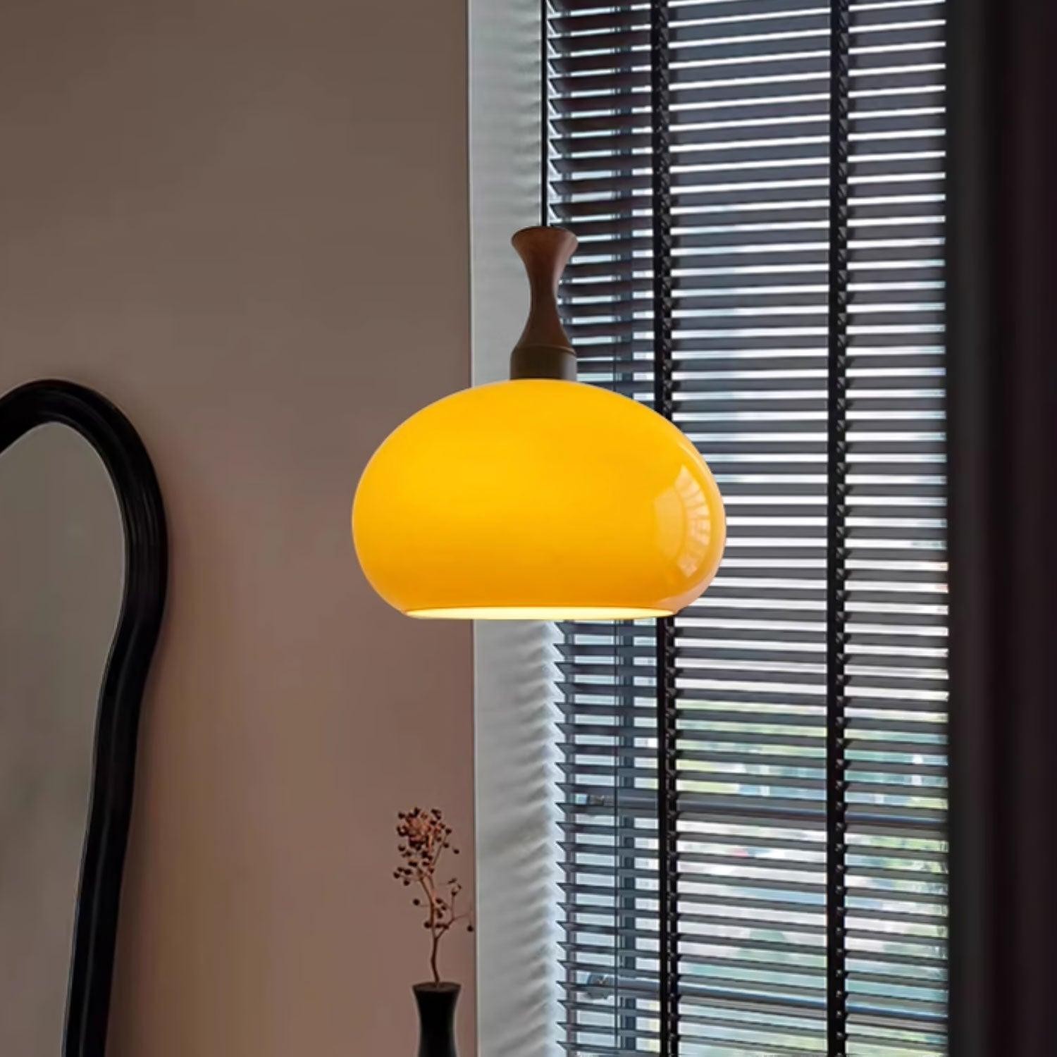 Świecąca pomarańczowa lampa wisząca w pobliżu żaluzji