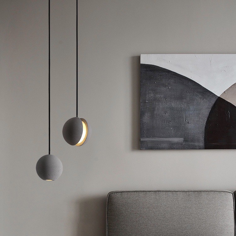 To pendellamper ved siden av en sofa og veggkunst