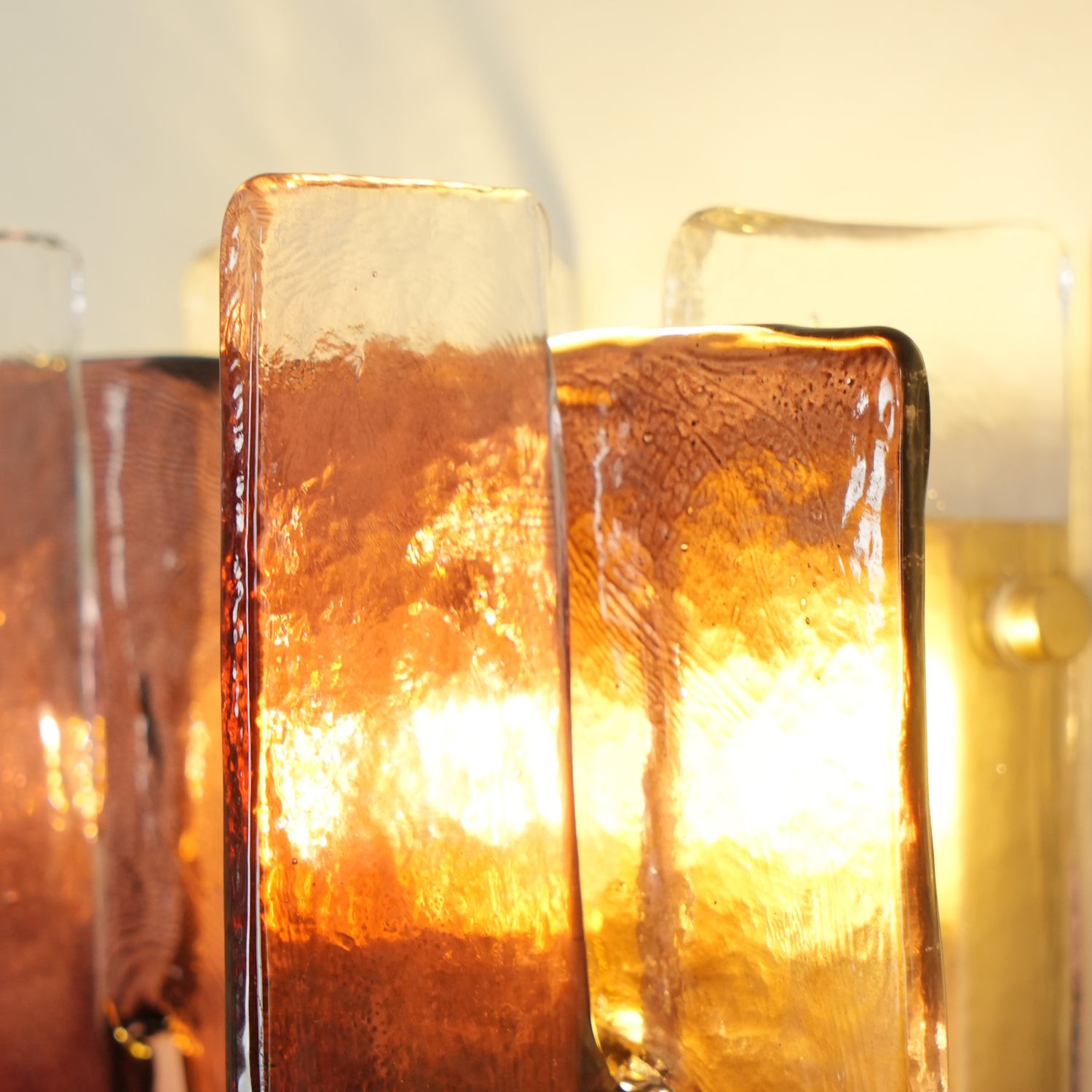 Detalle de cristal ámbar iluminado en la lámpara de pared Blason.