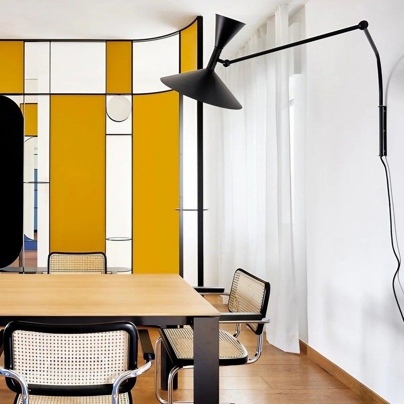 Black adjustable wall lamp near a dining table in a bright room